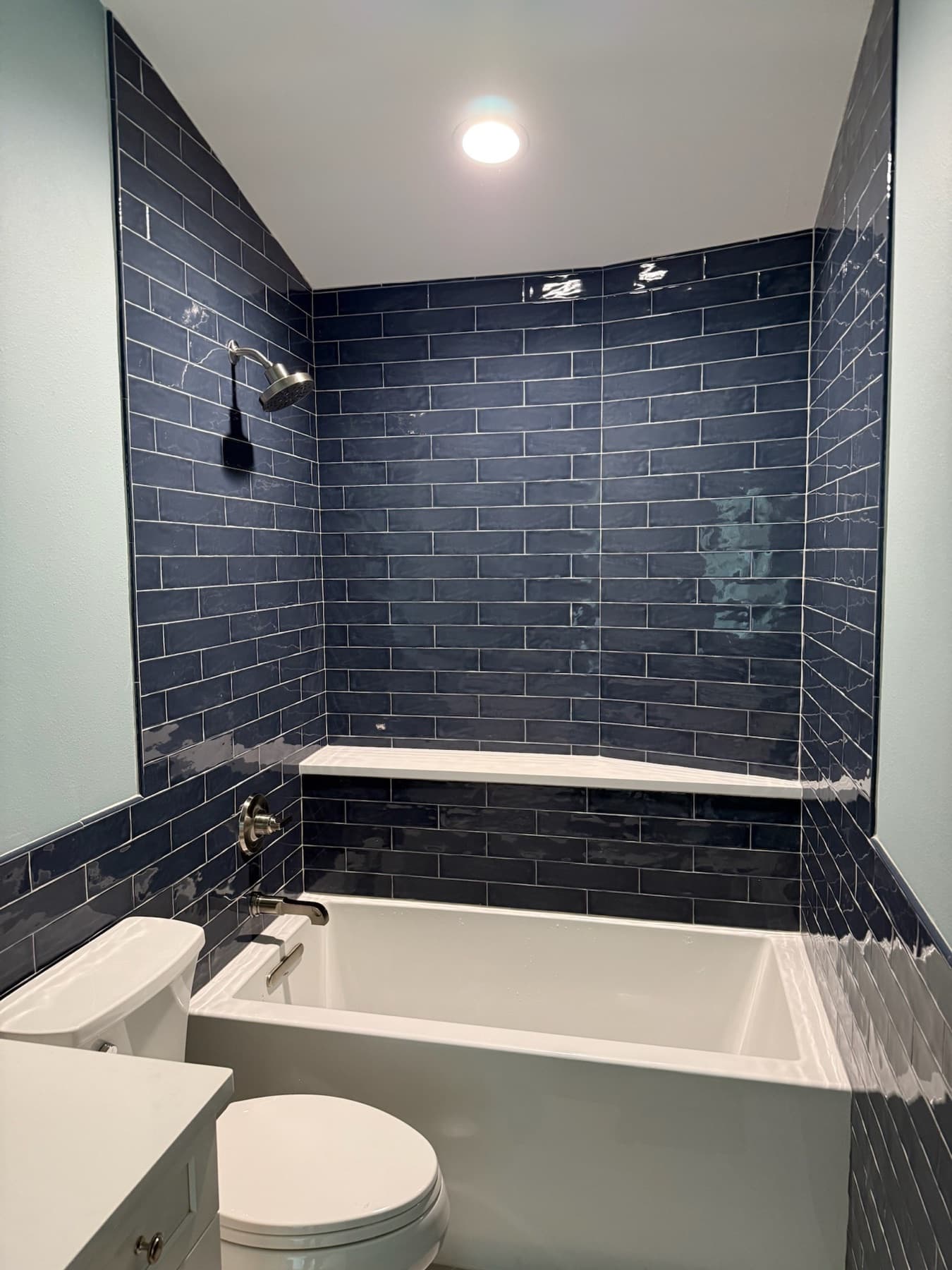 Navy blue subway tile tub surround with white tub in Milton, FL