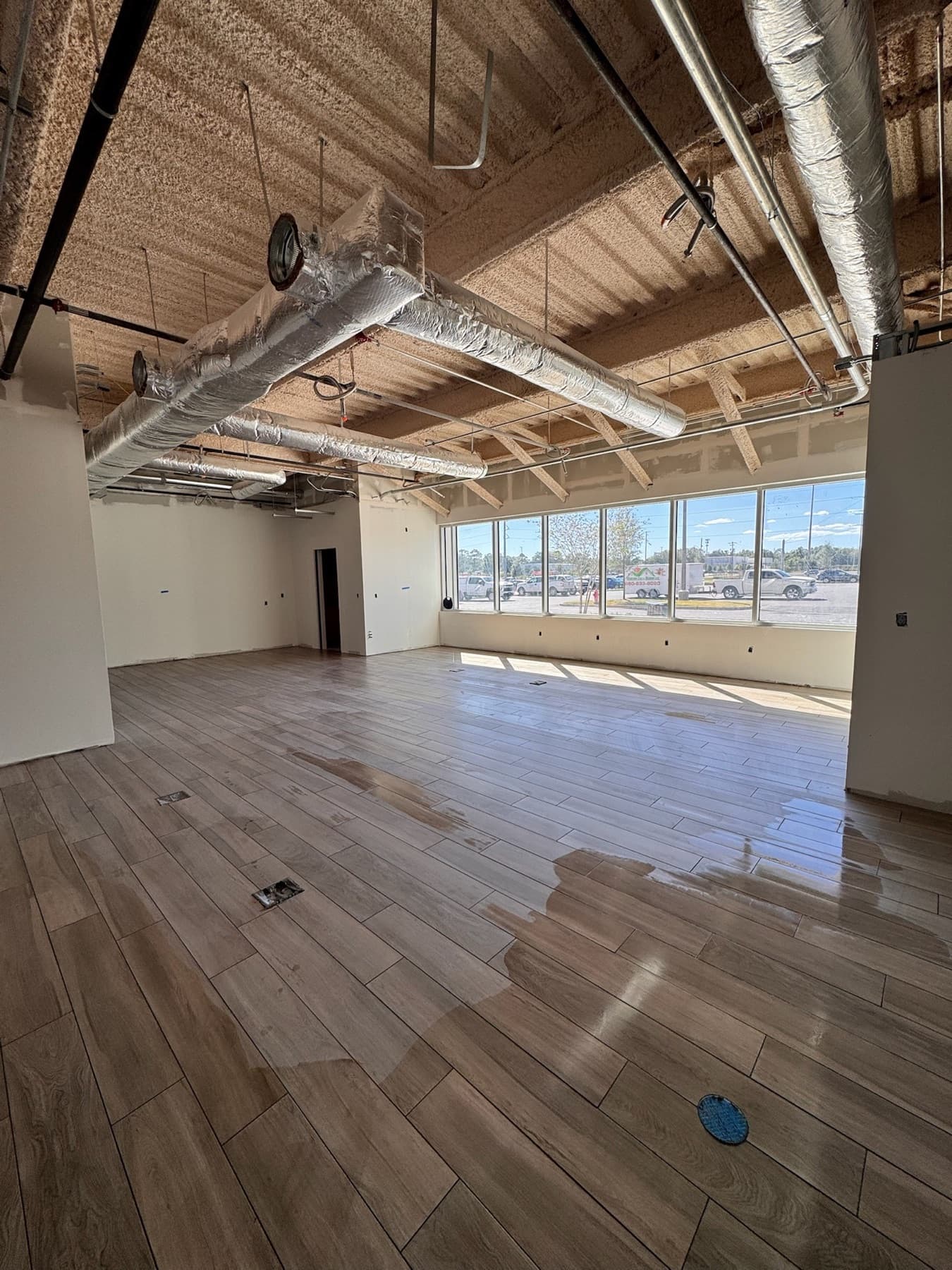 Open office with new luxury vinyl plank flooring and large windows in Pensacola, FL