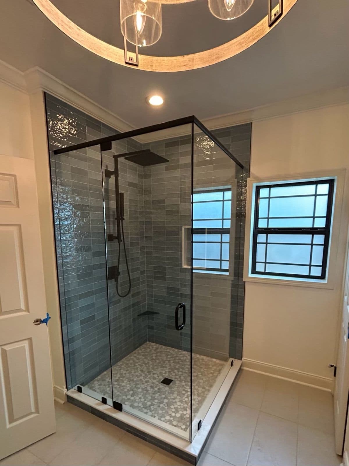 Custom tile shower installation in Pensacola, FL with grey vertical stacked tile and black frameless glass in Pensacola, FL
