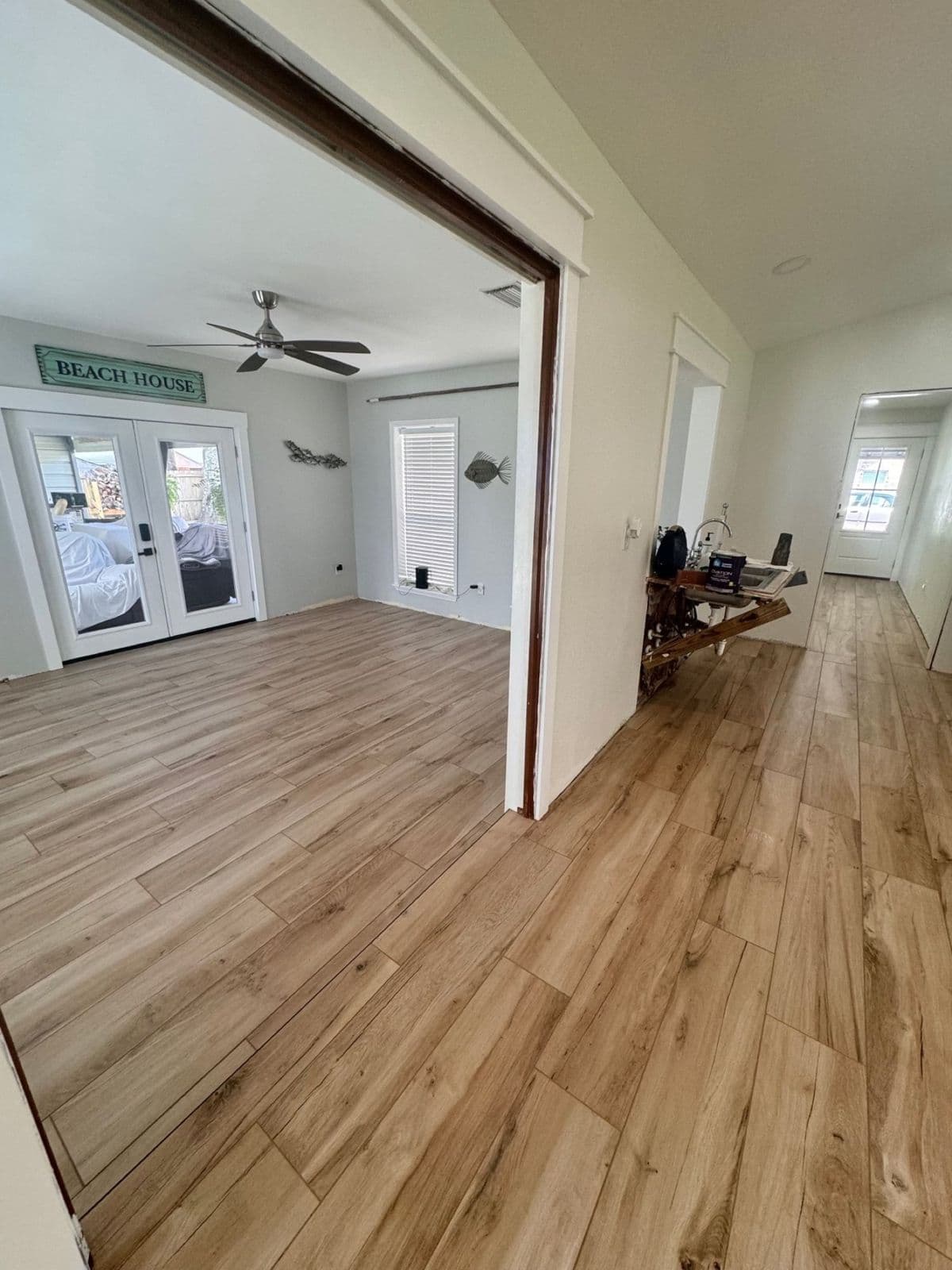 Luxury vinyl plank installation in Pensacola, FL: oak LVP through a beach house living room by Custom Tile & Design