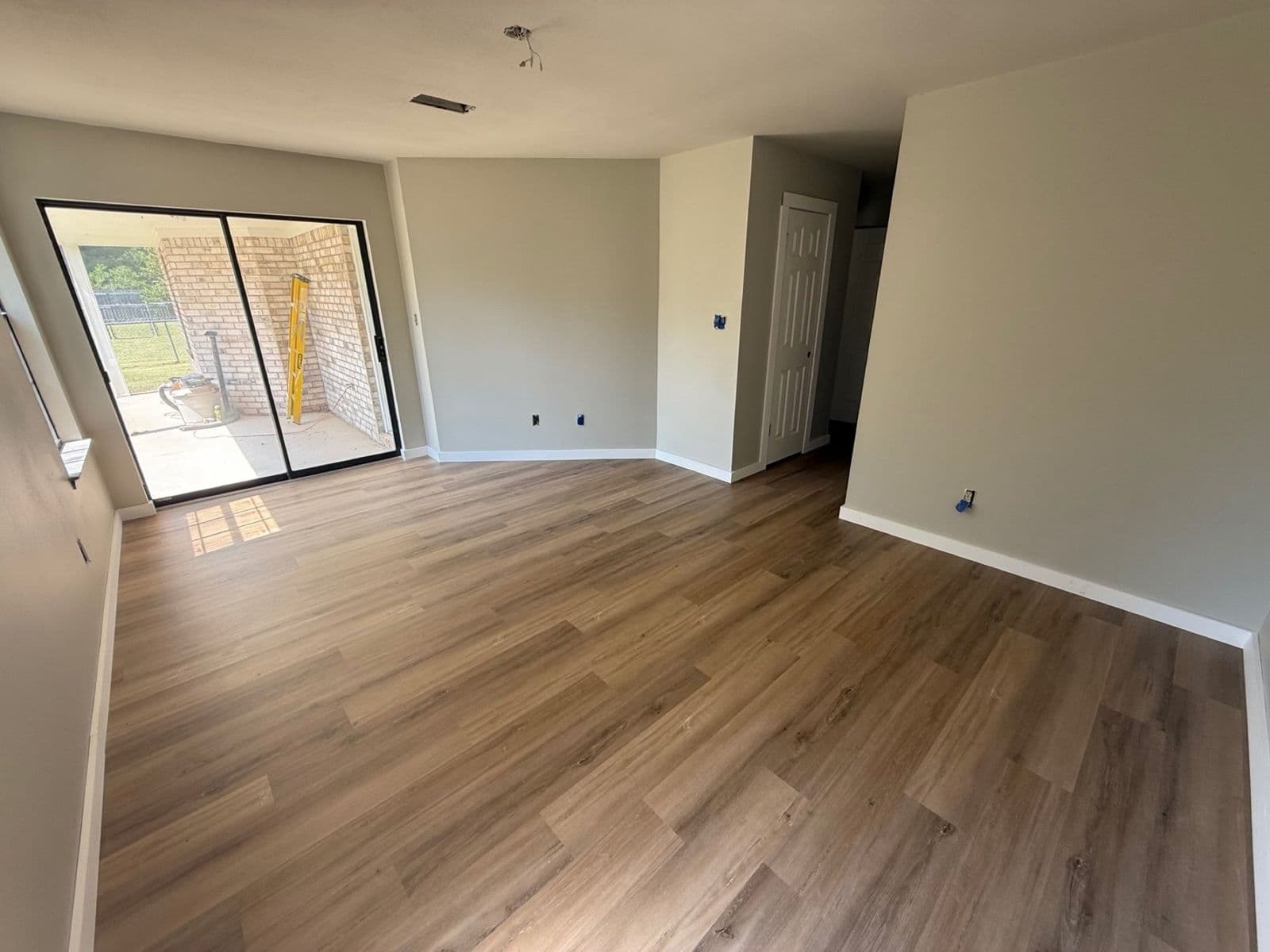 LVP flooring installation in Pensacola, FL: light oak luxury vinyl plank in an open living room by Custom Tile & Design