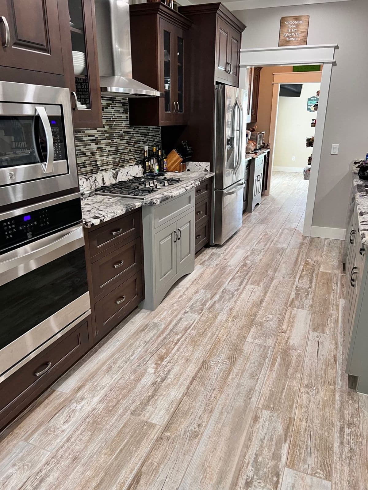 Kitchen backsplash and floor tile installation in Pensacola, FL: glass mosaic backsplash with whitewashed wood look tile in Pensacola, FL