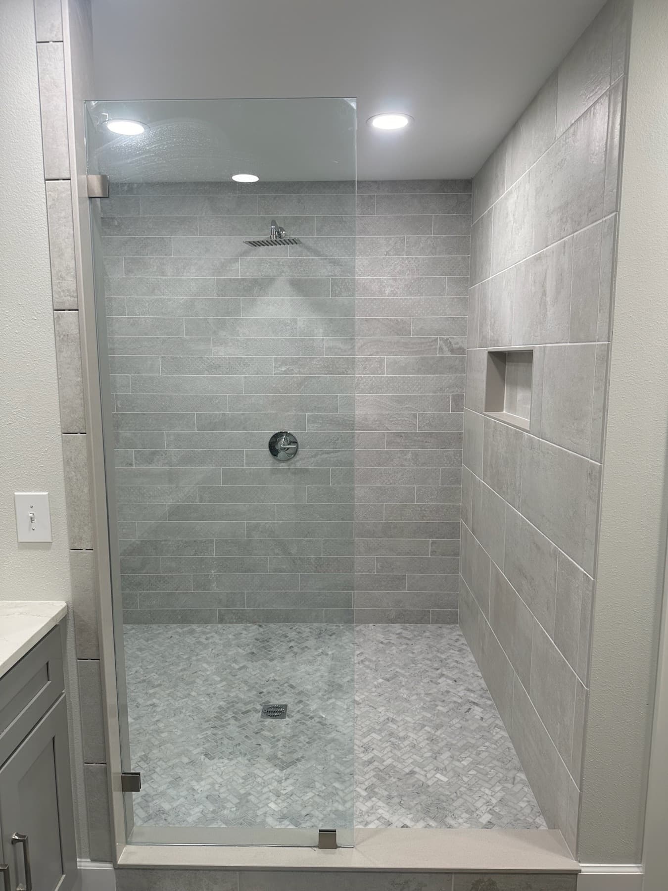 Grey large format tile shower with a recessed niche in Pace, FL