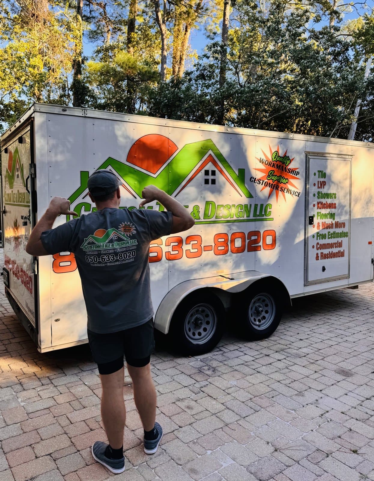 Oleg Glushko, owner of Custom Tile & Design, a Pensacola, FL tile contractor, in front of the company trailer
